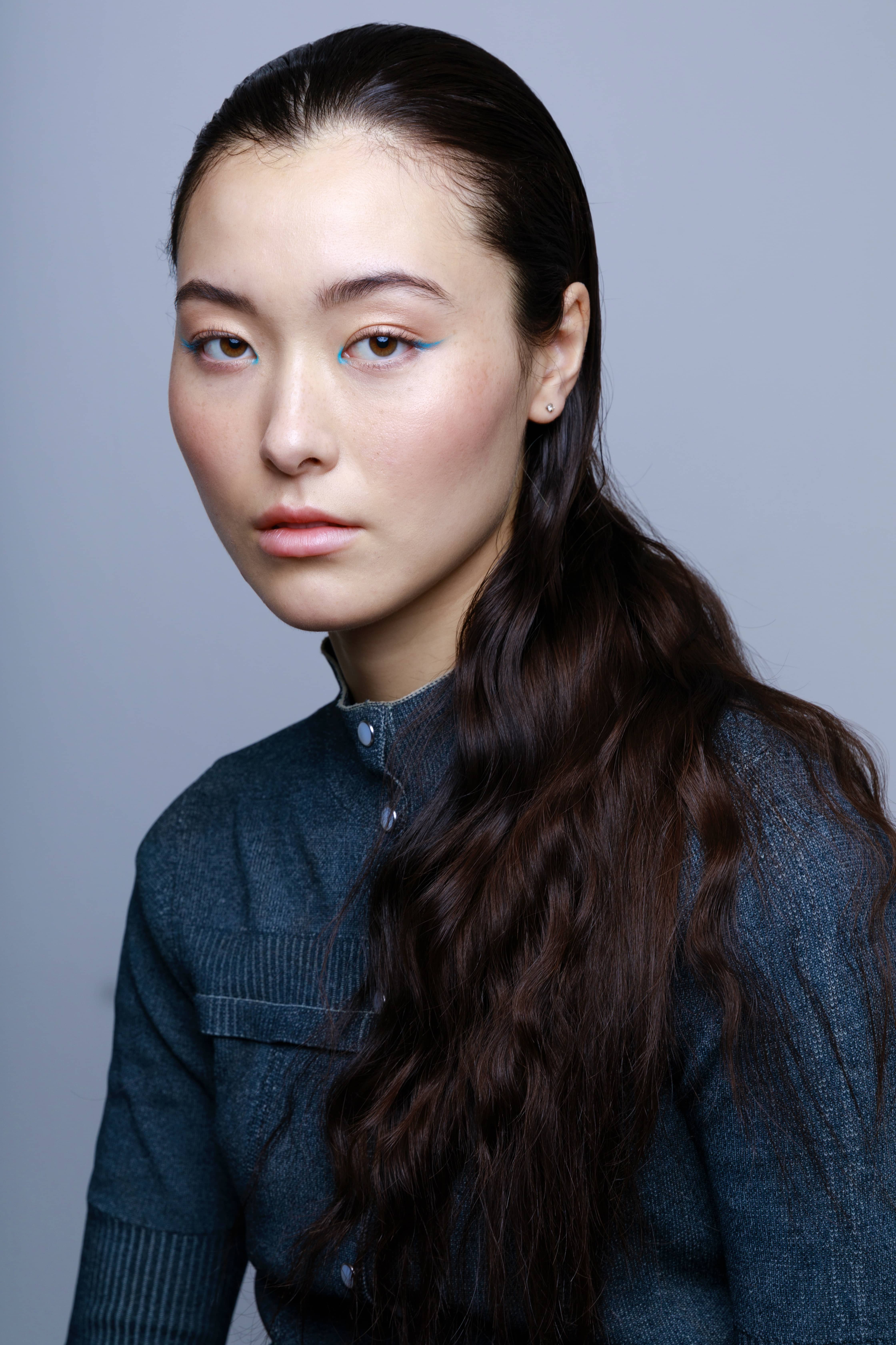 Woman with dark hair and blue eyeliner