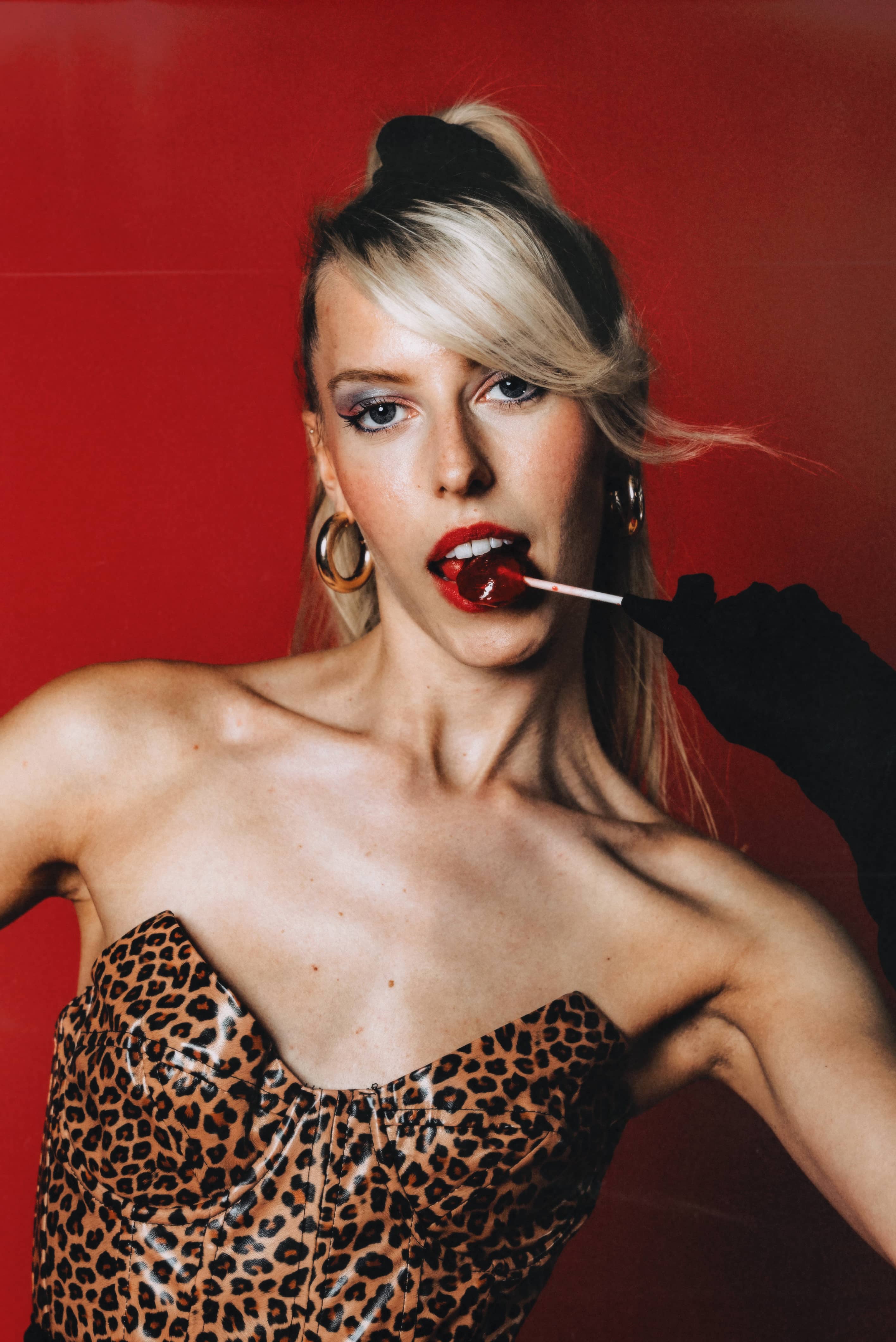 Woman with leopard print clothing and lolipop