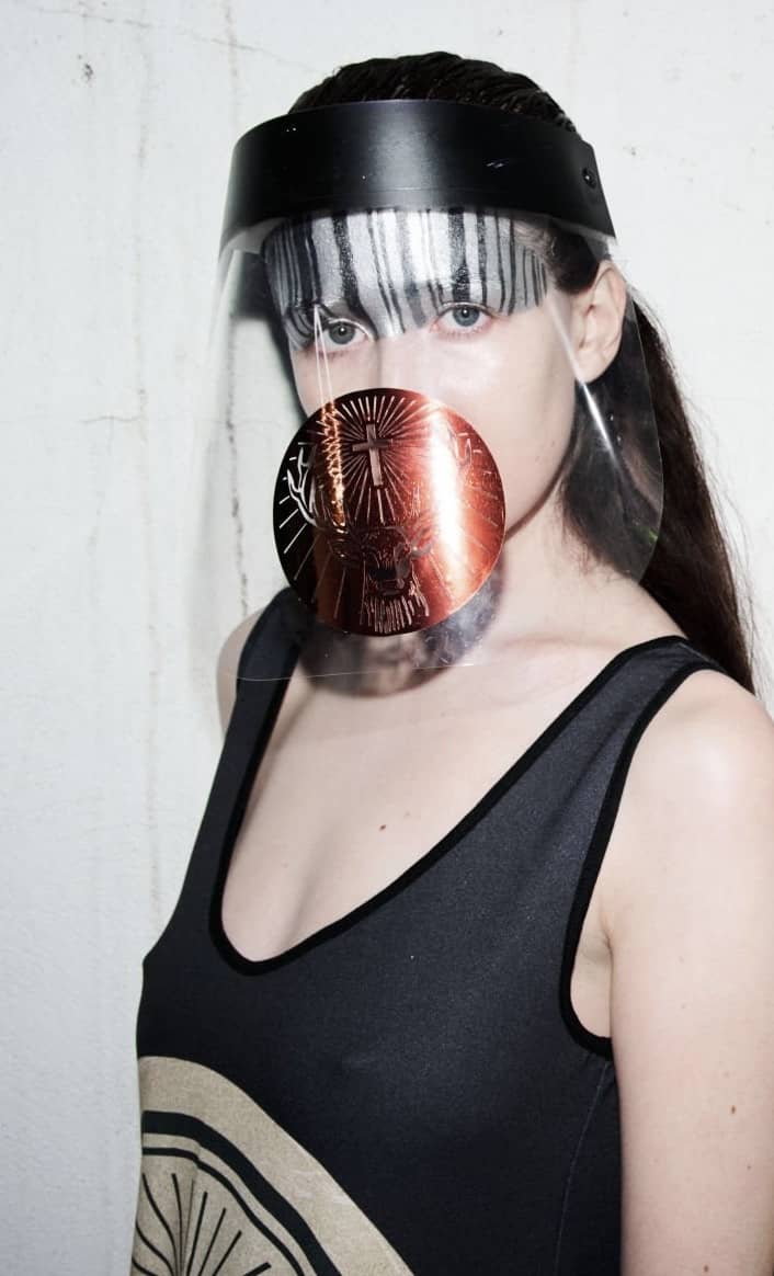 Woman with transparent face mask with a crimson seal on it