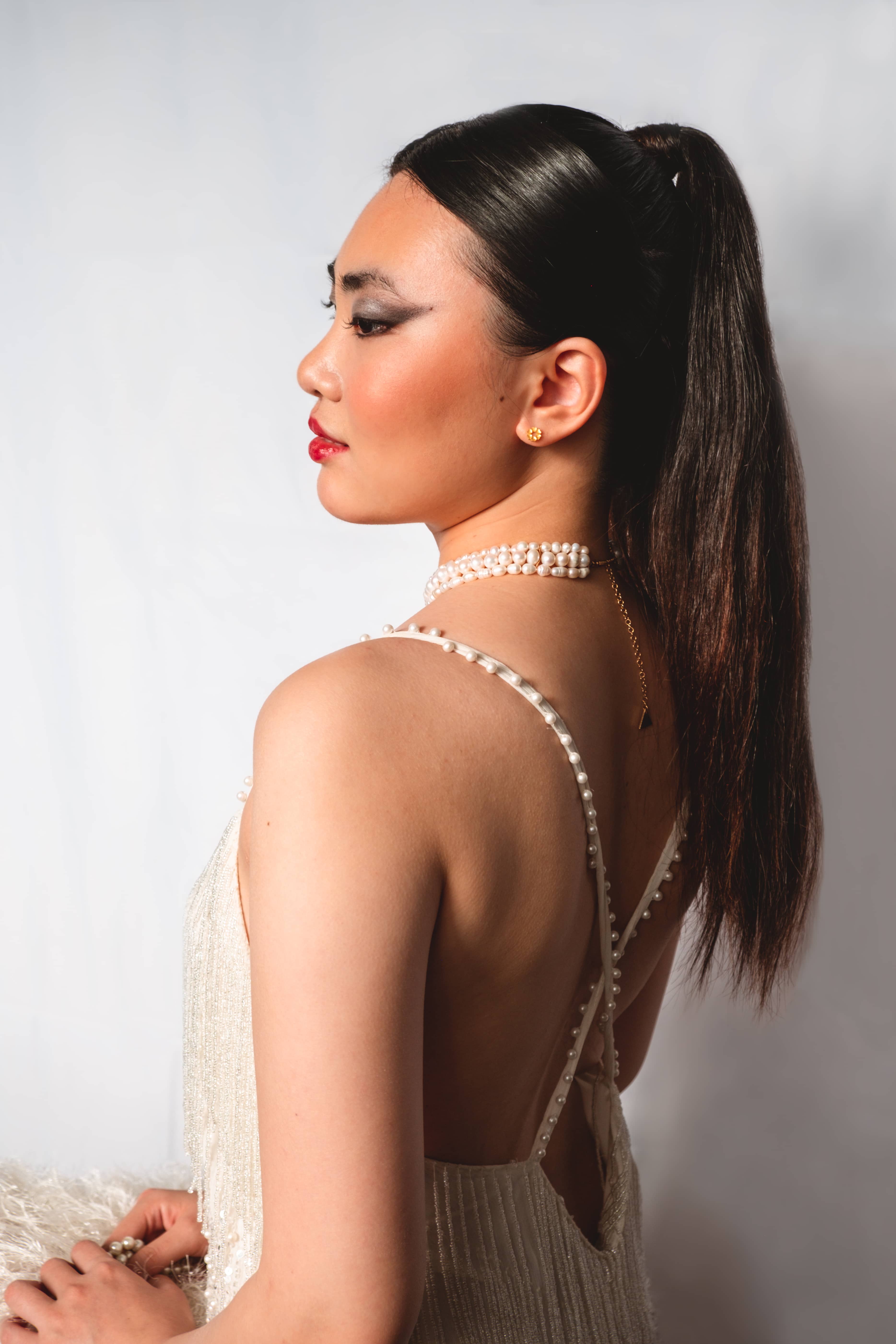 Woman with white dress and pulled-back hair, side-view