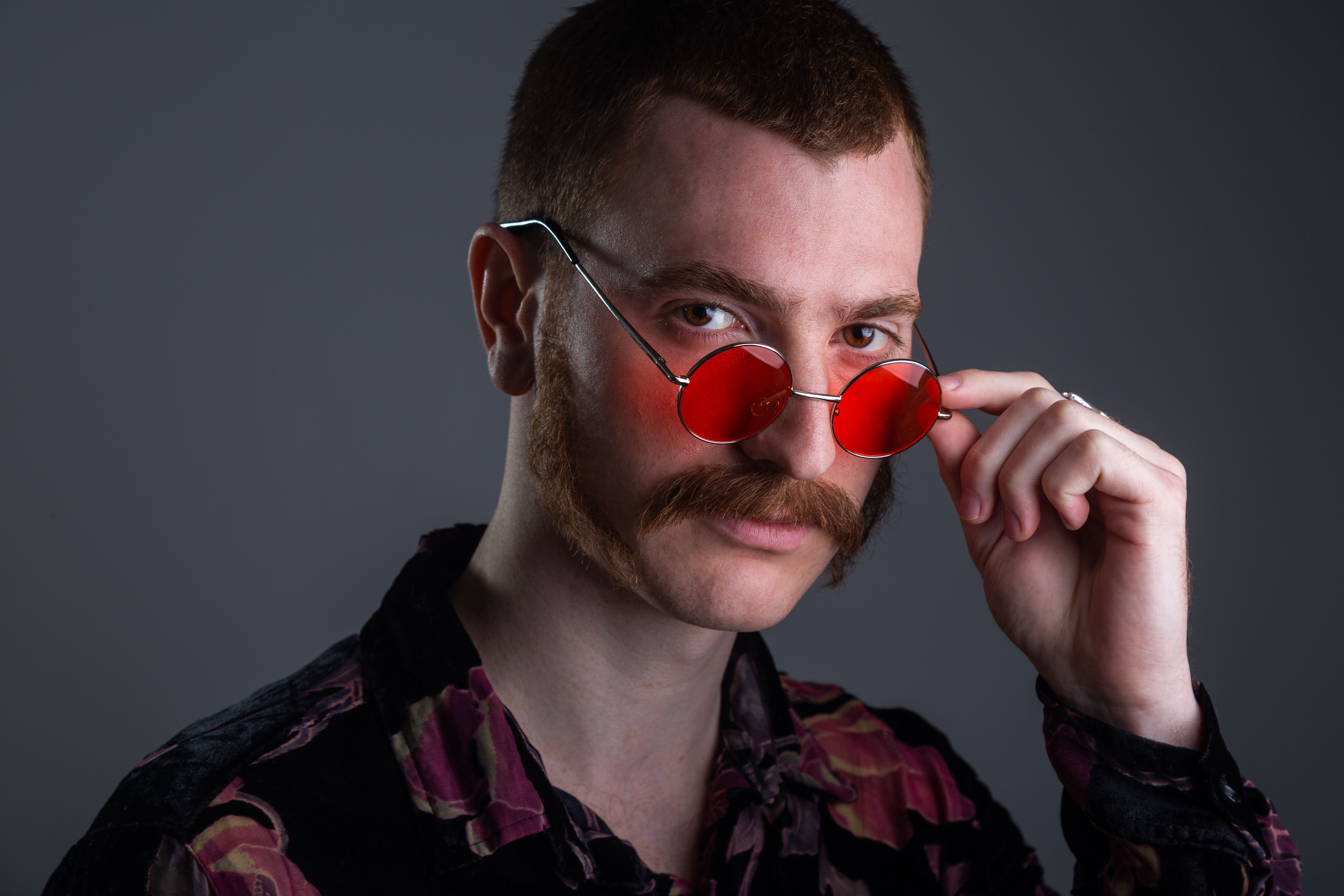 Man with facial postiche (sideburns and moustache) and retro glasses front-view