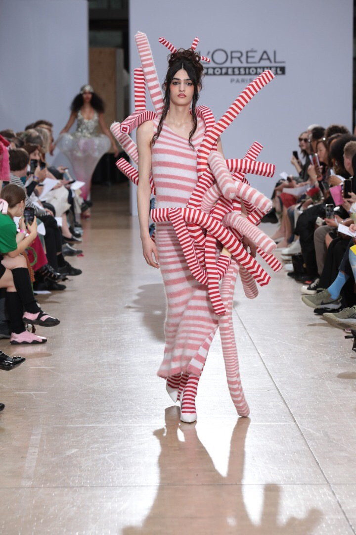 Woman with red and white striped tubes in fashion show
